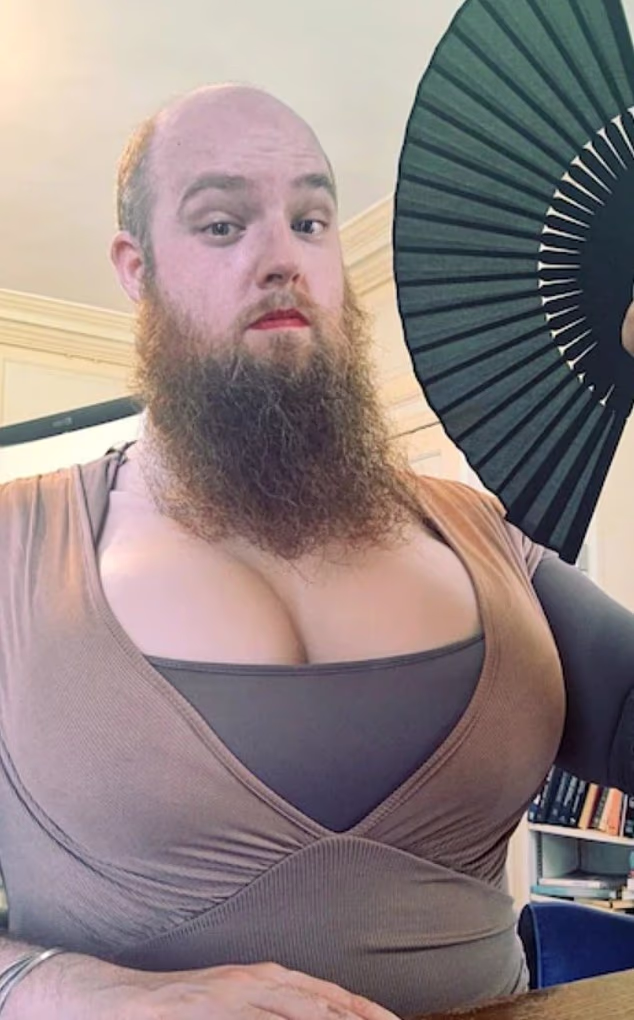 Bearded Oxford University lecturer teaches female students while wearing large fake breasts, low-cut tops, red lipstick and nail varnish