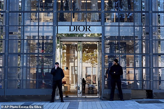 Two security guards are seen protecting the entrance to a shop for the luxry brand Dior